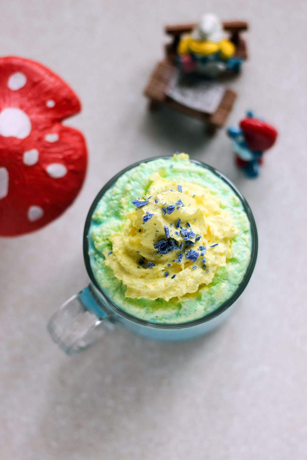 Blue hot drink with yellow whipped cream and vintage Smurf toys