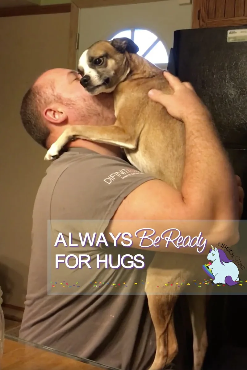 Dog hugging a man in a kitchen. 