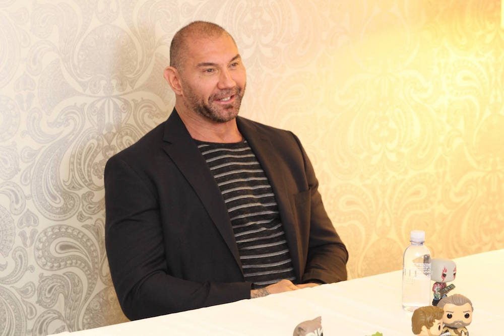 Dave Bautista sitting at a table.