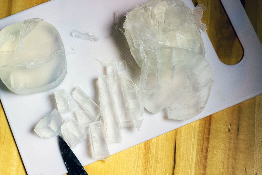 Cutting clear soap on a cutting board. 