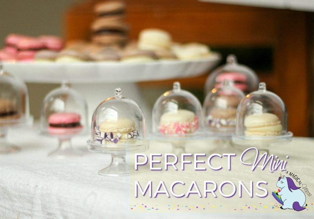 Mini macarons in tiny clear cake stands. 