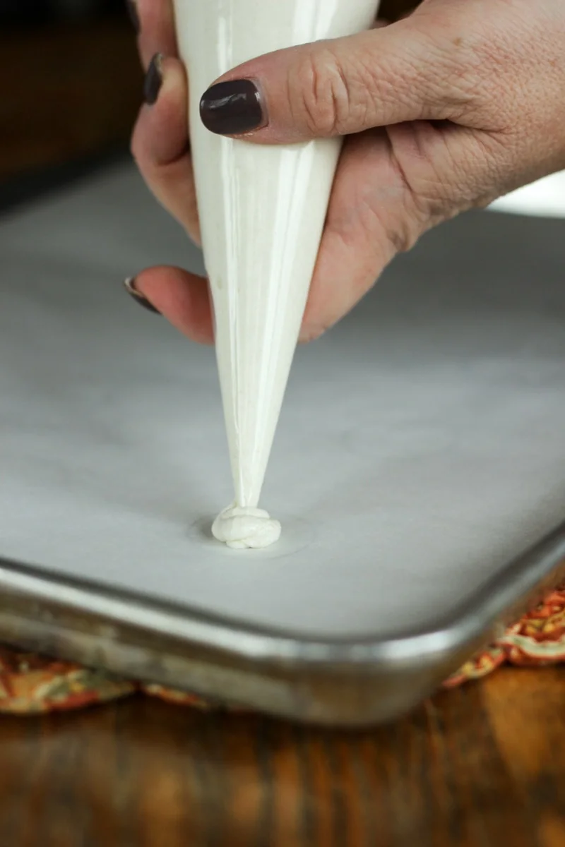 Piping batter onto parchment paper. 