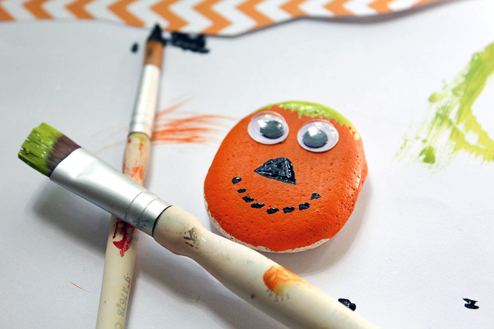 Painting a rock to look like a pumpkin. 