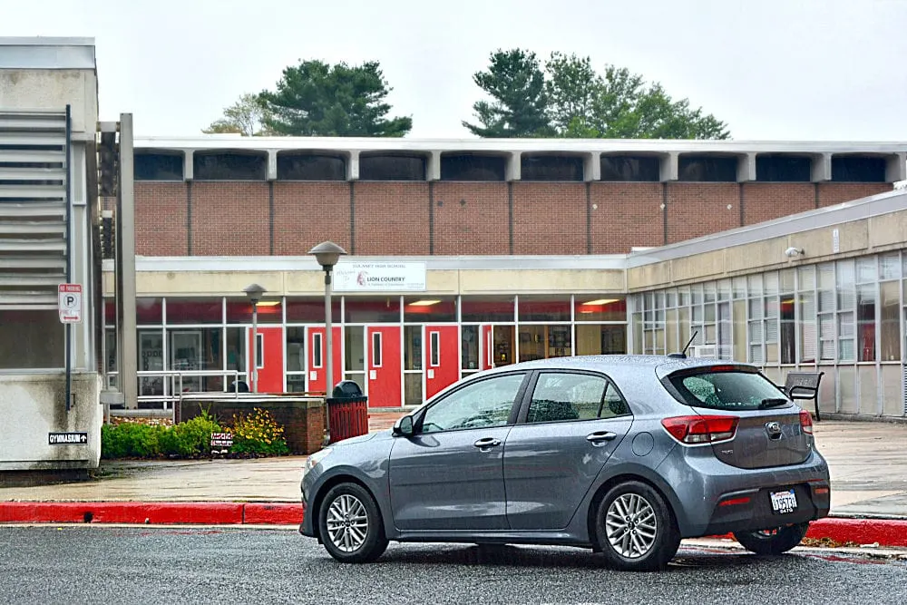 Kia in front of a building. 