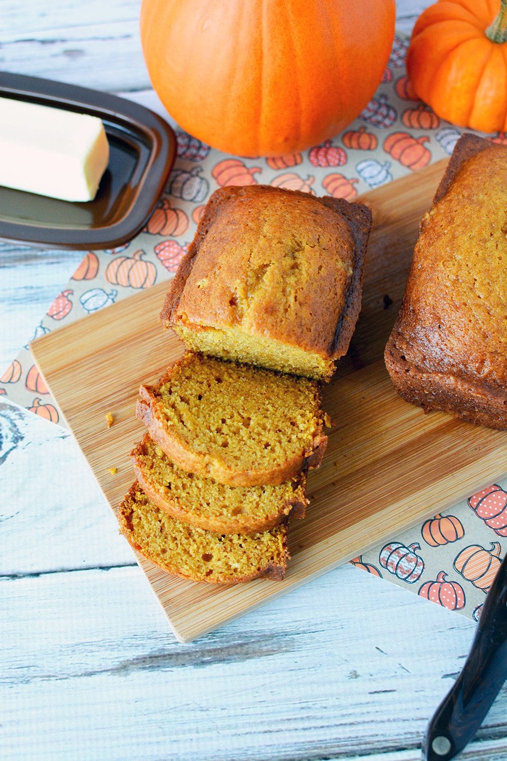 Pumpkin bread sliced on a cutting board.