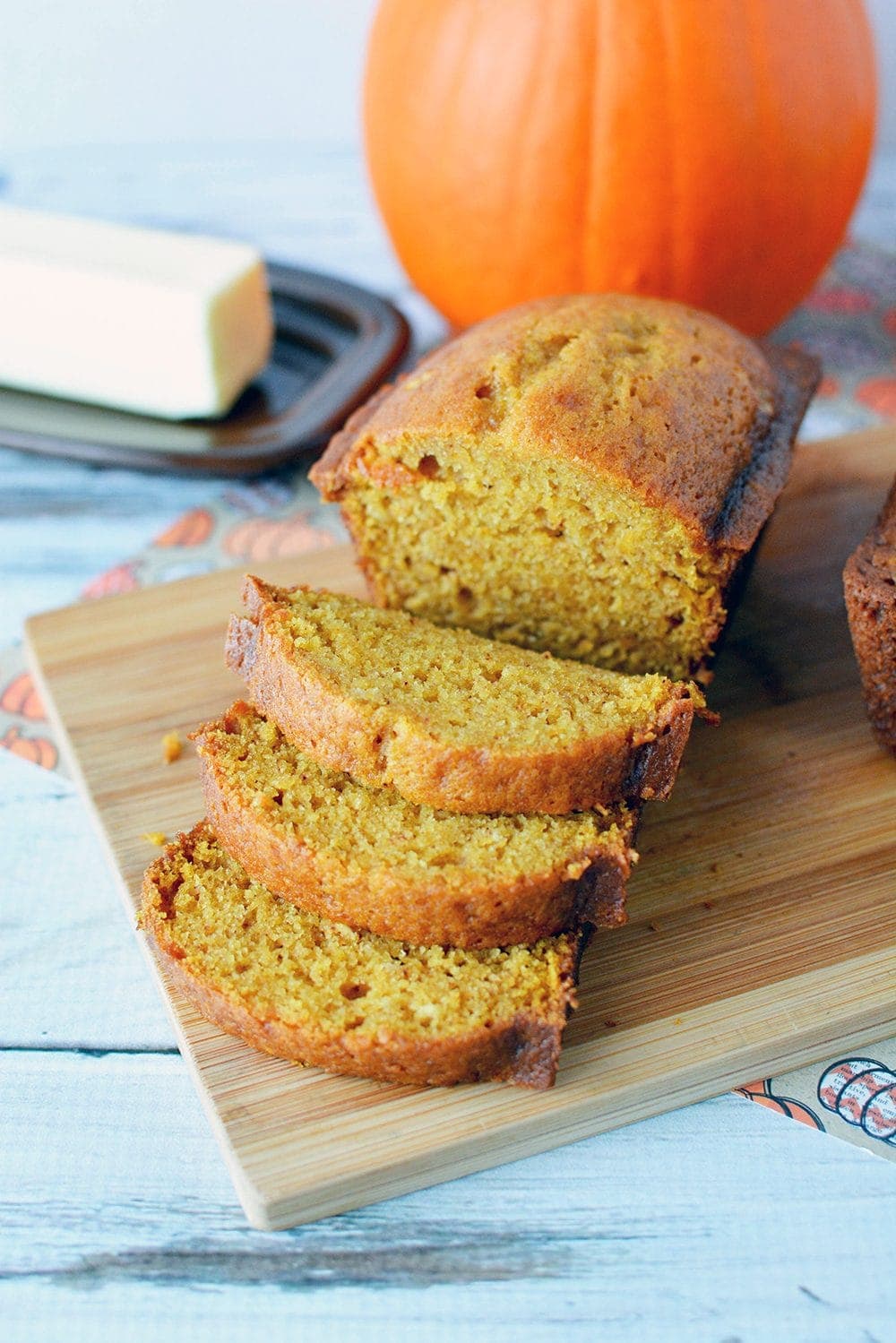 Pumpkin bread on a board with slices. 