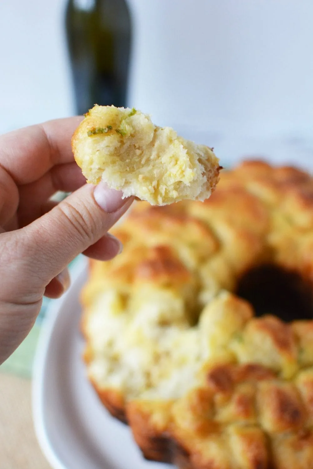 Holding a piece of cheese pull apart bread.