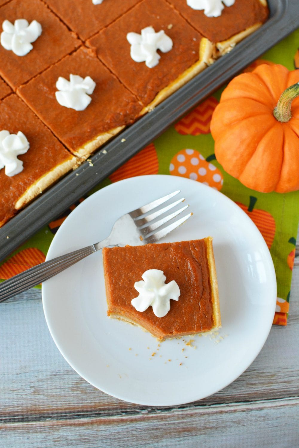 Slice of pumpkin pie on a plate with a bite taken out