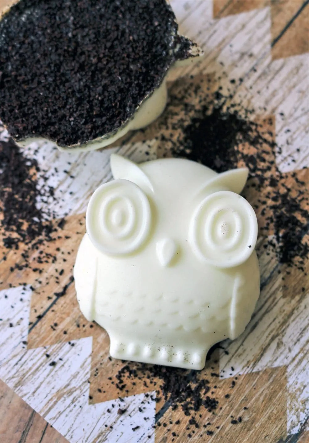Soap in the shape of an owl with coffee grounds on the table. 