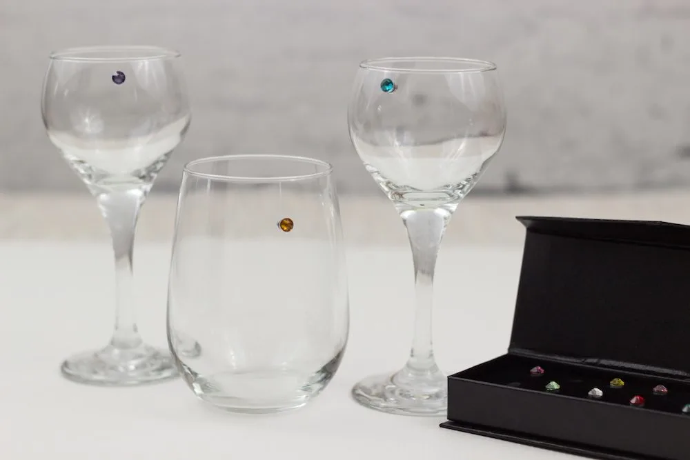 Wine glasses with gems on them and a box with the rest of the wine charms. 