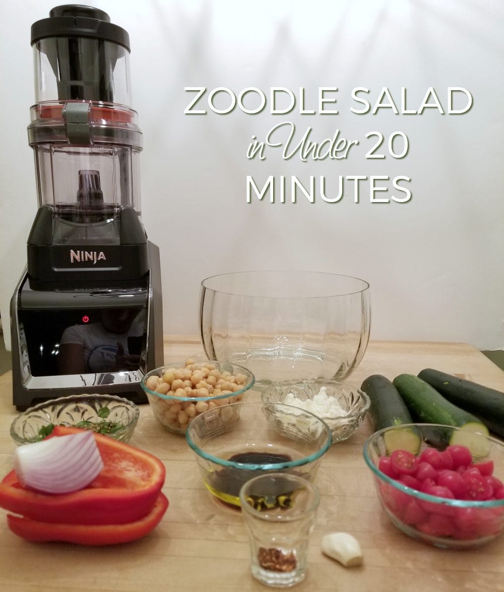 Ninja blender and zoodle salad ingredients on a table. 