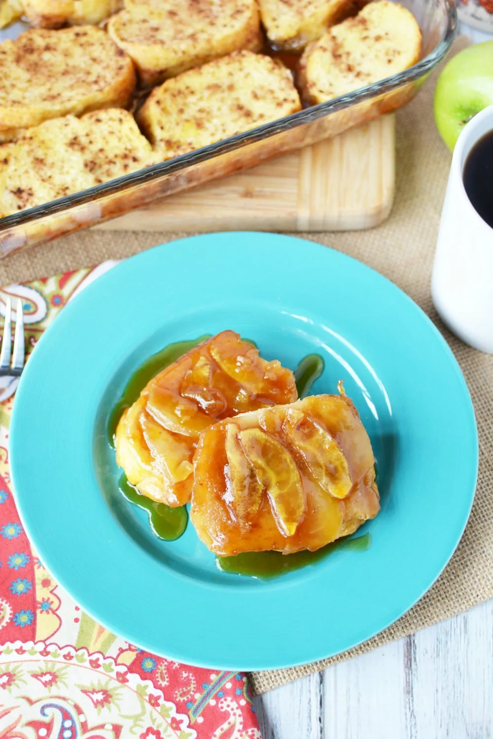 French toast on a blue plate topped with apples.