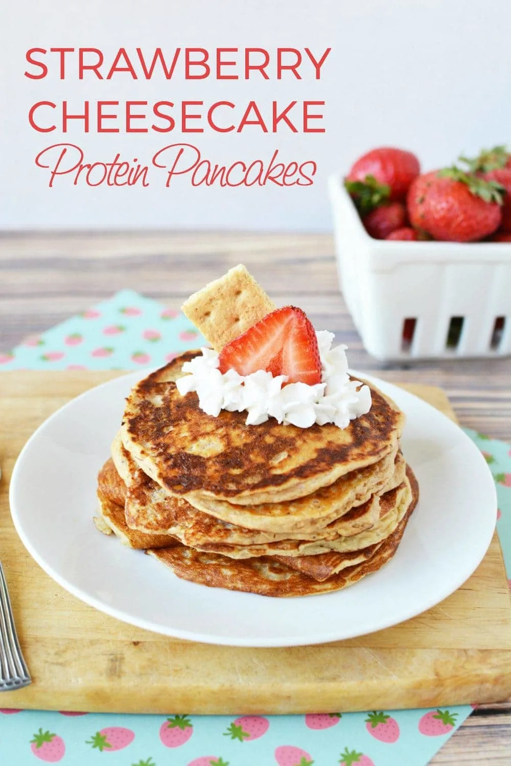 Pancakes stacked with whipped cream and strawberries on top. 