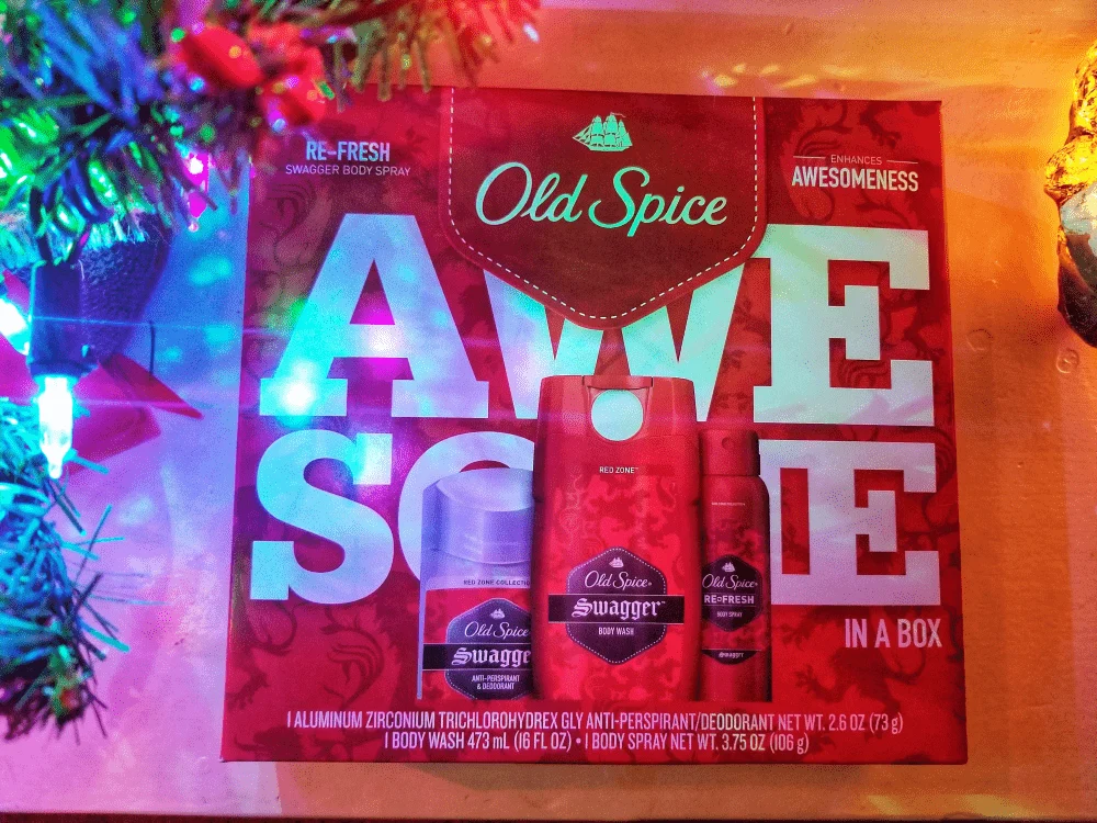 Old Spice gift set in a red box next to a Christmas tree with lights. 