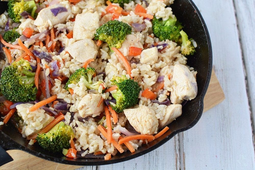 Ginger chicken with veggies and rice in a skillet. 