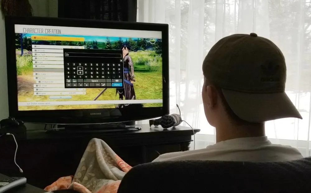 Adam playing an anime video game. 