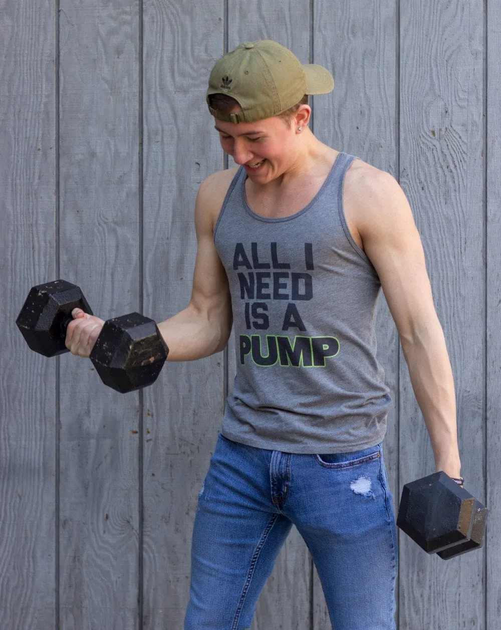 Teen lifting weights in a "all i need is a pump" tank top. 