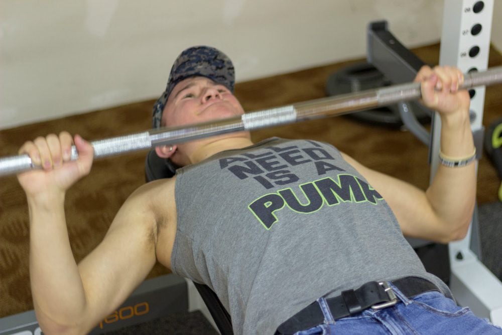 Teen lifting weights in a shirt that says "All I need is a Pump."