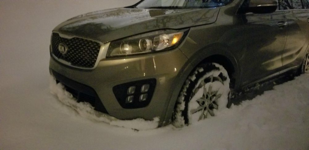 Kia with the tires in the snow