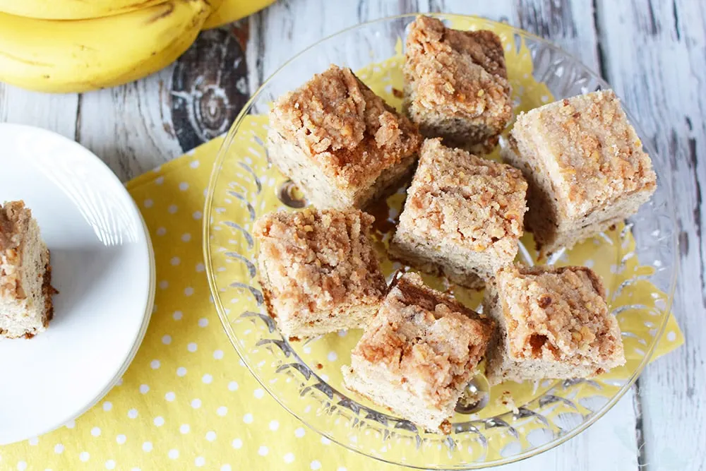 Banana Nut Coffee Cake squares on a clear plate. 
