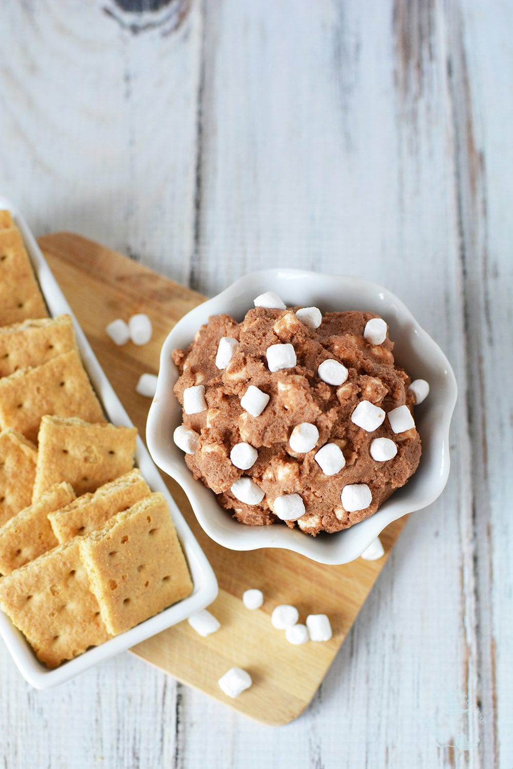 Chocolate cookie dough with marshmallows next to graham crackers.
