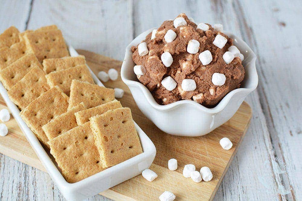 Mini graham crackers next to s'mores cookie dough dip. 