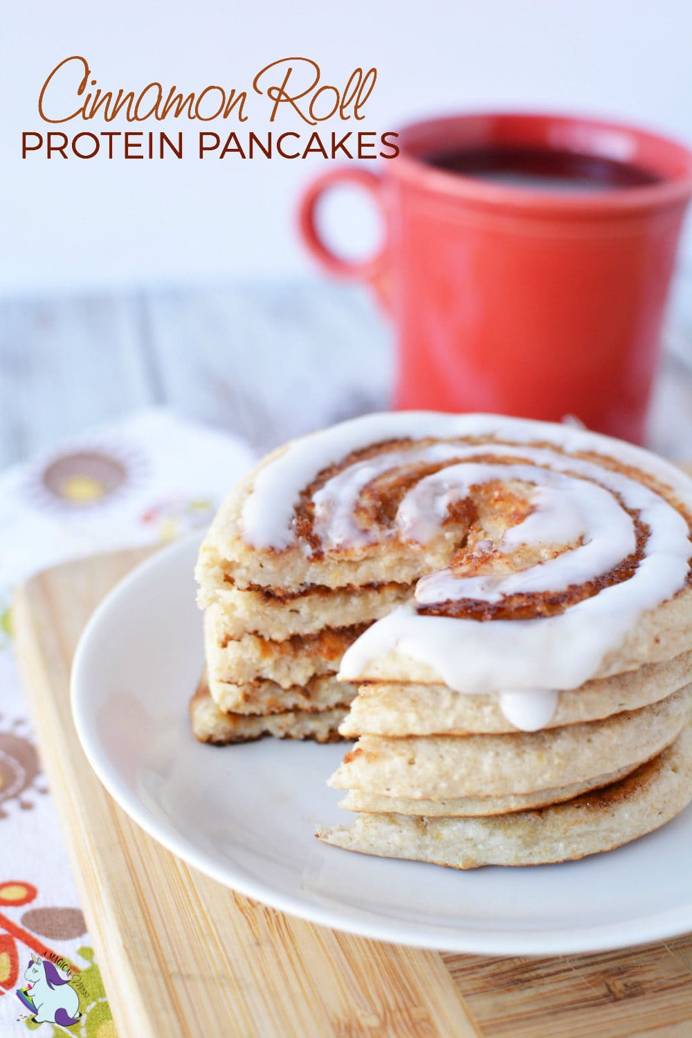 Cinnamon roll pancakes with some missing in front of a red coffee mug. 