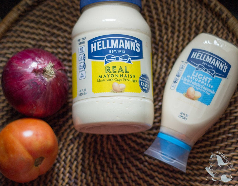 Onion, tomato, and two containers of mayo on a tray.