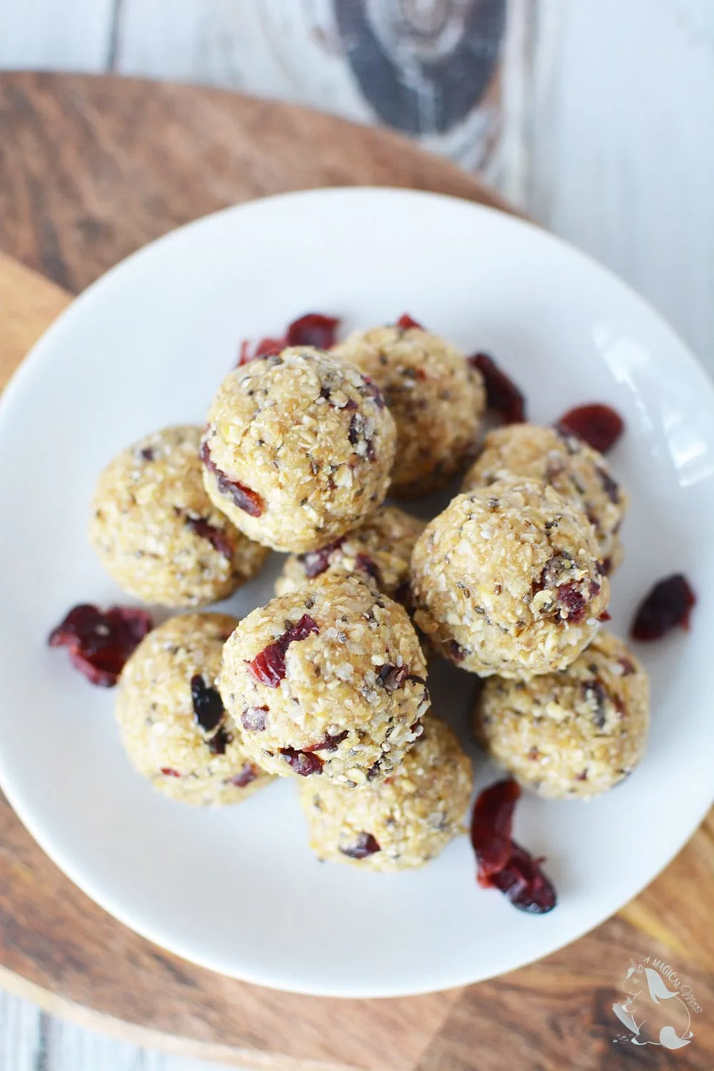No bake energy balls with cranberry on a white plate. 