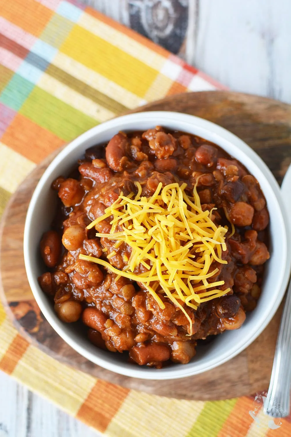 Overhead shot of chili with beans topped with shredded cheese. 