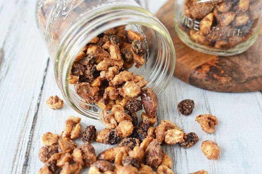 Snack mix with nuts and raisins dumped out of mason jar.