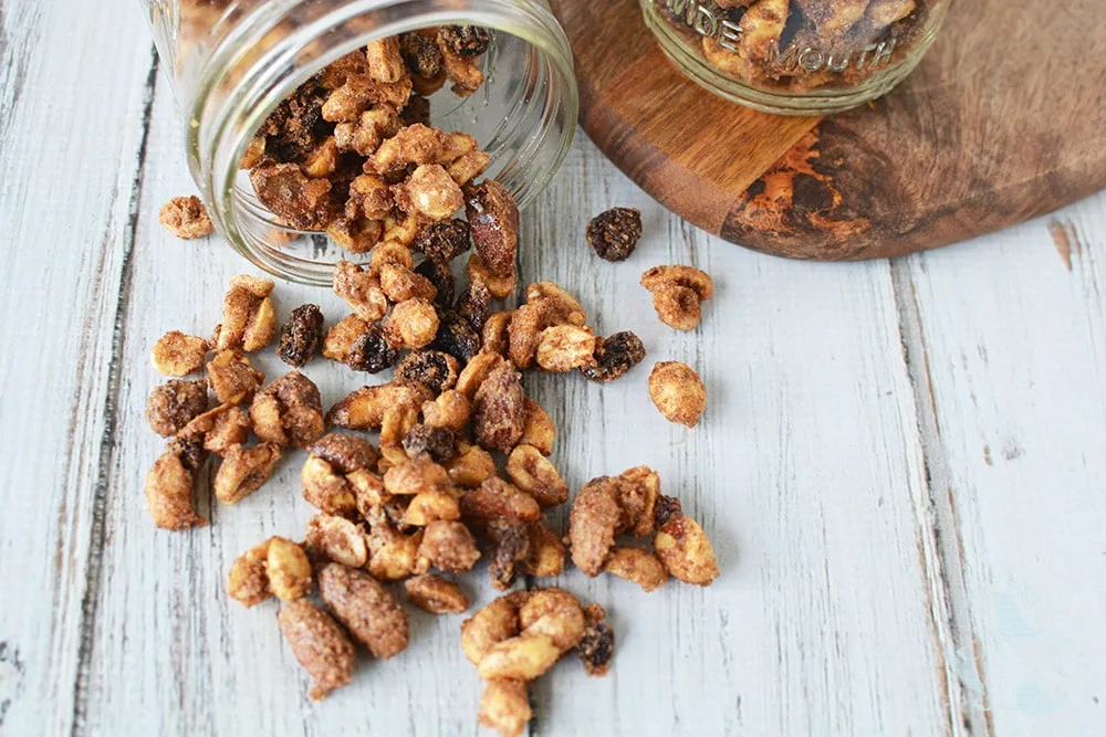 Snack mix mixture out of mason jar and on table.