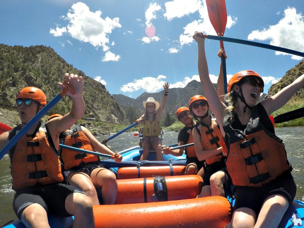 Happy people in a boat who just survived their first white water rafting experience.