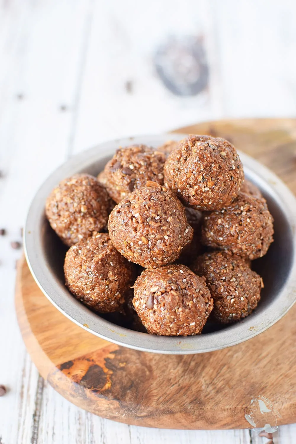 Chocolate energy bites in a bowl on a board. 