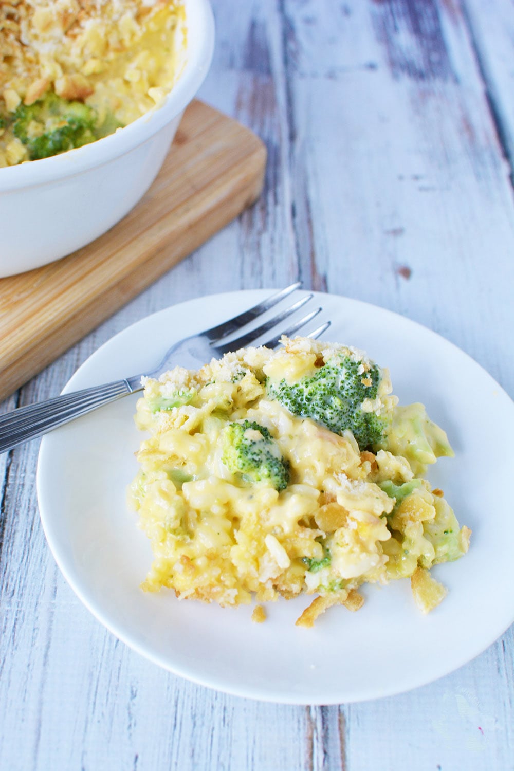 Broccoli and cheese casserole with cracker topping on a plate with a fork. 