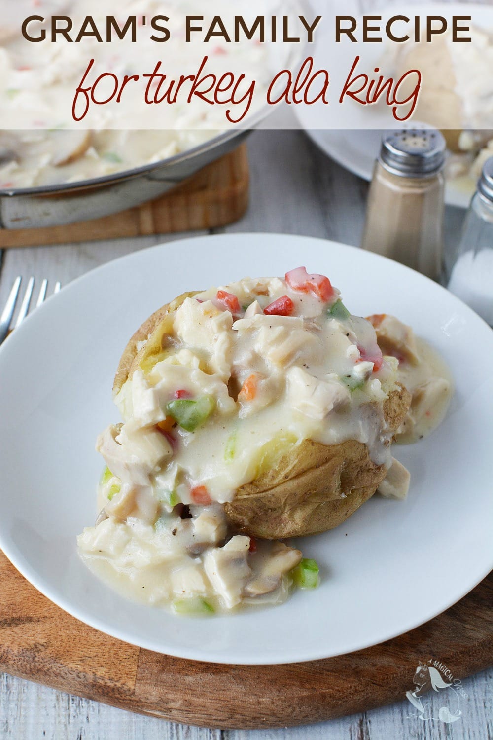 A baked potato on a plate topped with creamy turkey a la king. 