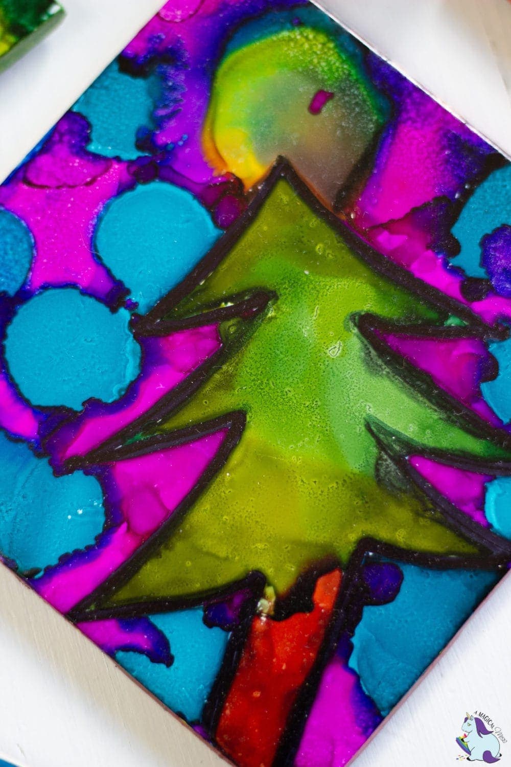 Colorful holiday tree design using alcohol ink on a ceramic tile. 