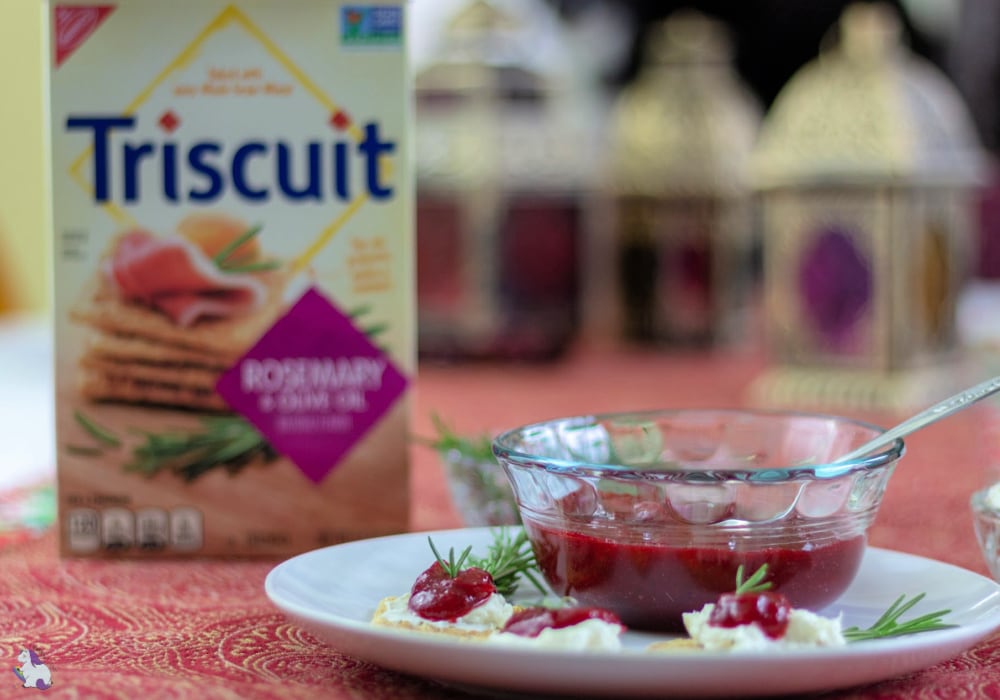 Bowl of cranberry jam and box of Triscuits on a table