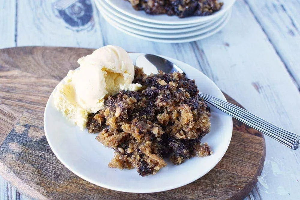 Peanut butter chocolate cake on a plate with vanilla ice cream