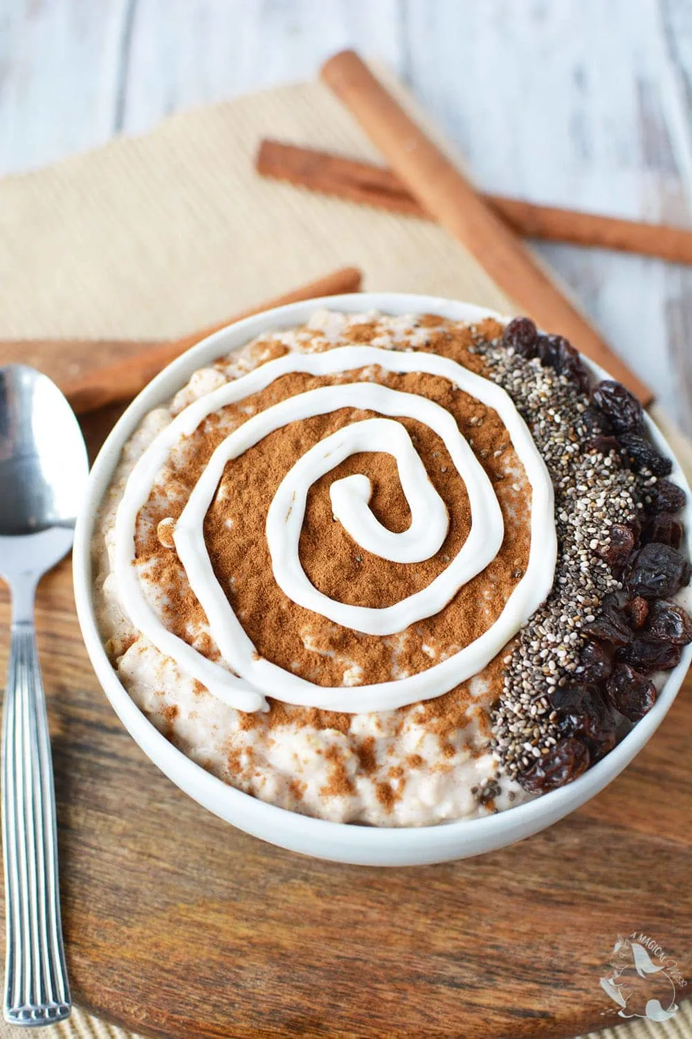 Smoothie bowl with cinnamon, yogurt swirl, raisins, and chia seeds. 