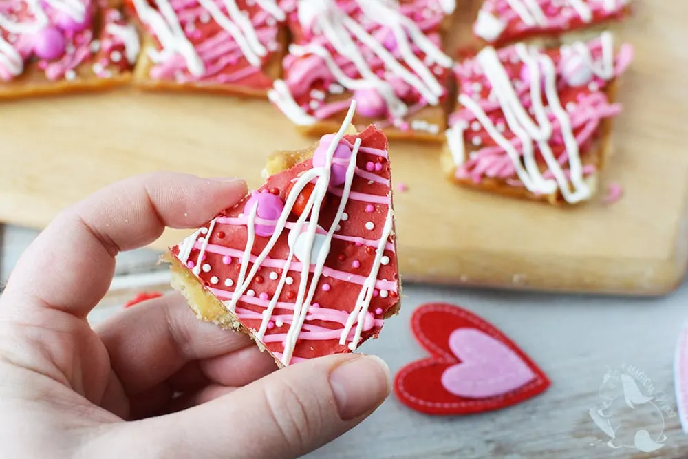 Holding a piece of saltine toffee.