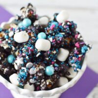 dark purple candy covered popcorn with marshmallows and sprinkles