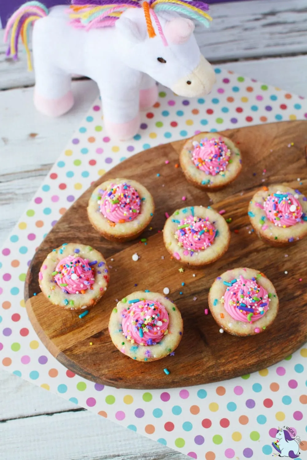 wooden tray of cookie cups with pink frosting