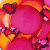 red hearts in alcohol ink on tile