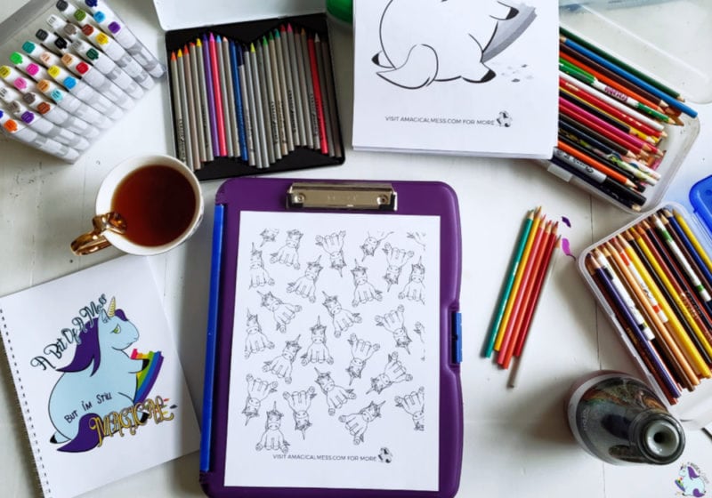 unicorn coloring pages on workspace with art supplies