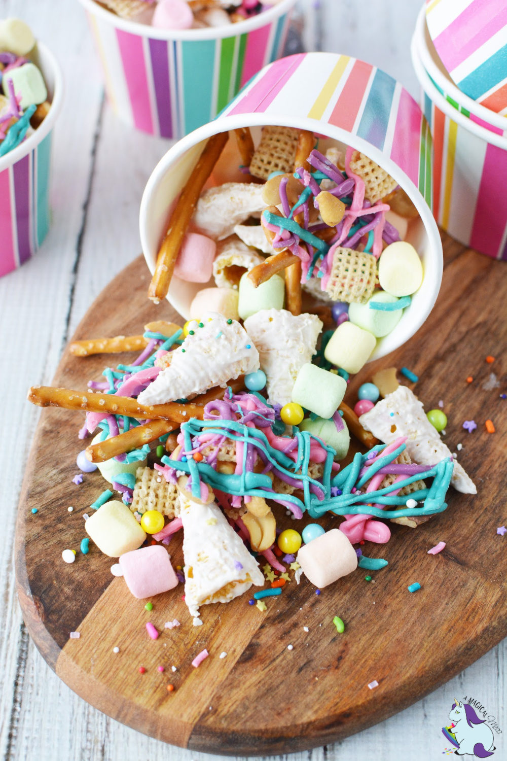colorful unicorn snack mix spilling out of striped paper cup