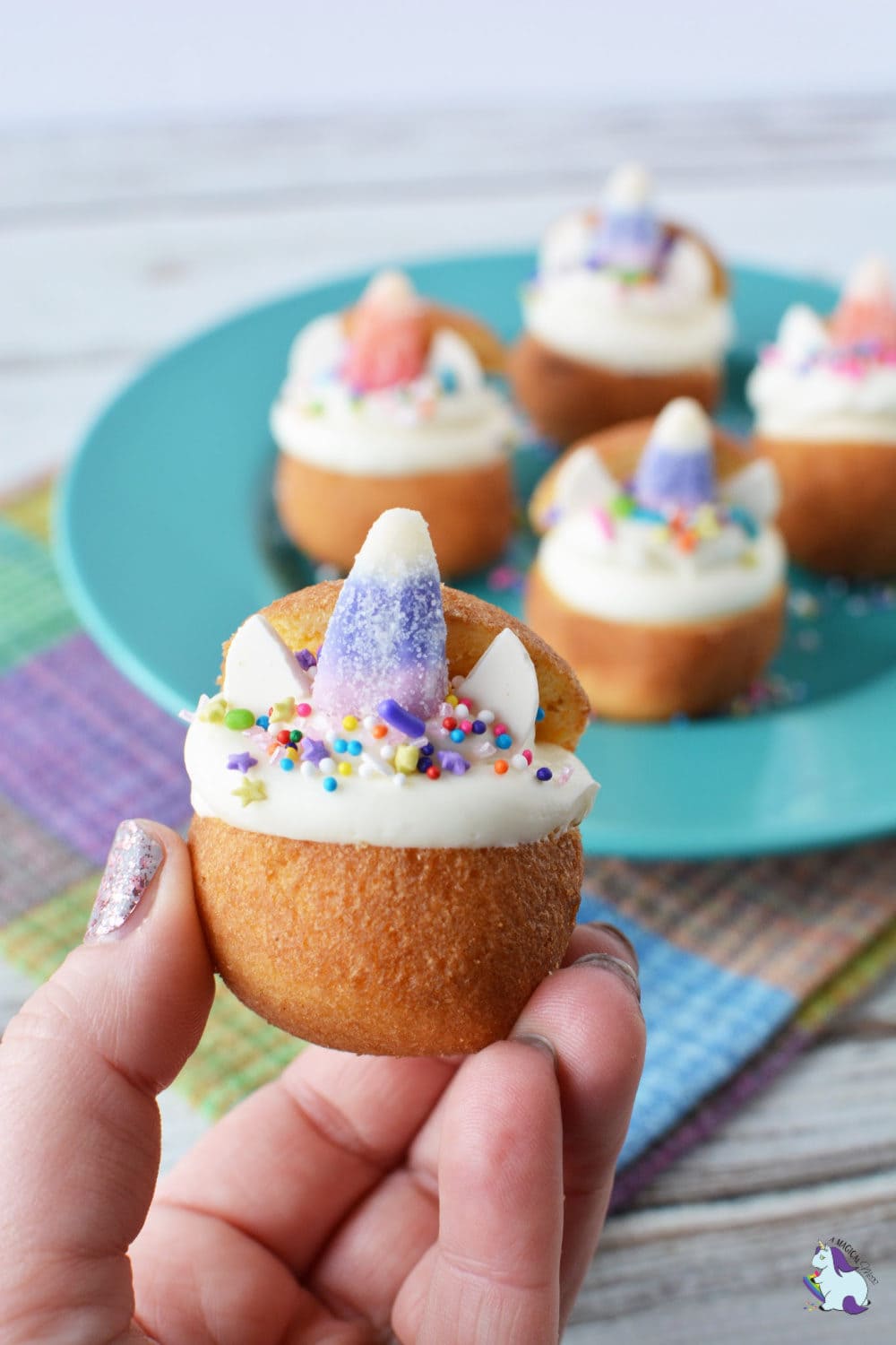 Donut hole filled with white frosting, sprinkles, and candy corn.