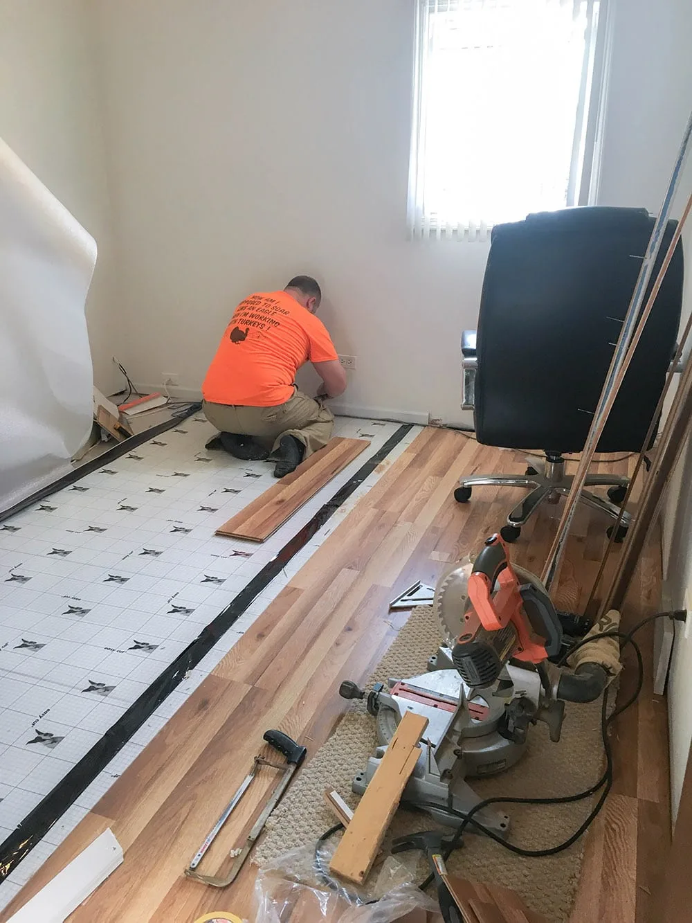 Husband installing new vinyl plank flooring. 