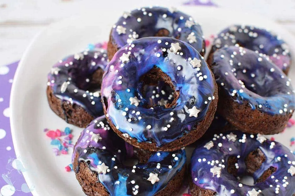 Galaxy donuts stacked on a plate. 