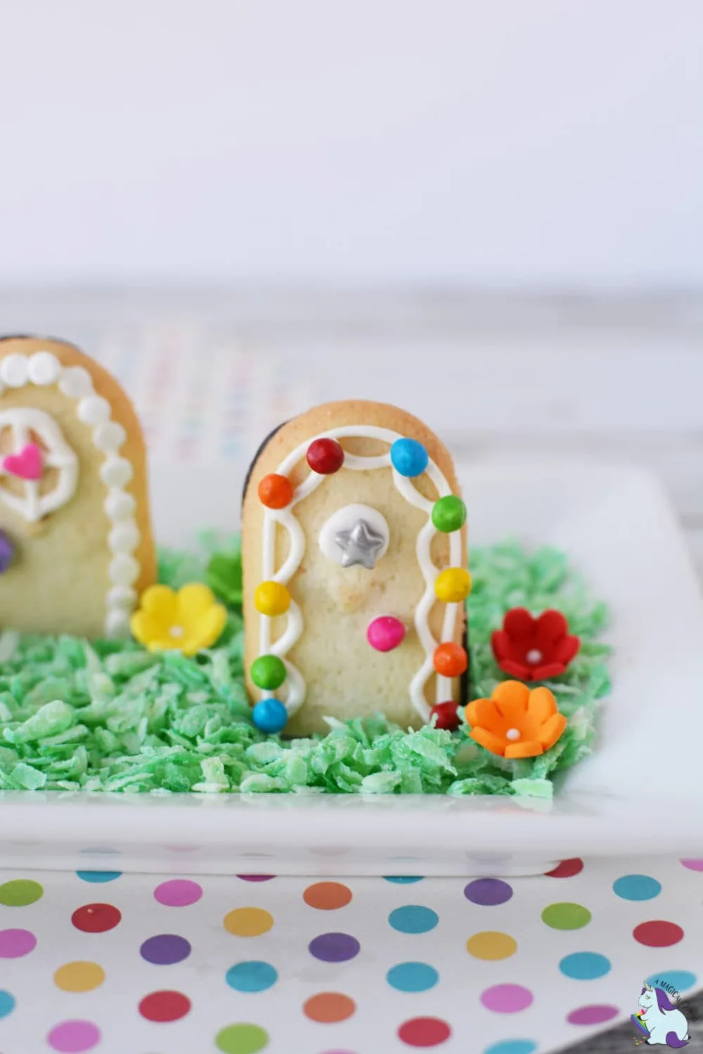 Cookies decorated like fairy doors on top of edible grass. 